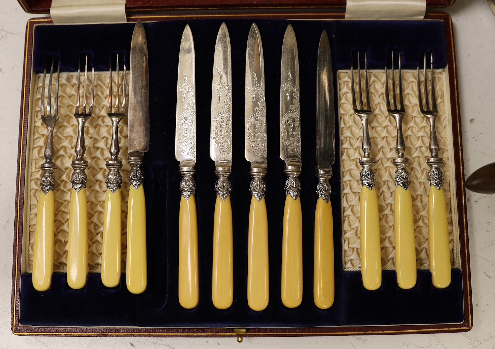 A case of twelve silver handled tea knives, one damaged, Sheffield 1931, two pairs of silver plated wine coasters including 19th century, a plated cafe au lait pair and two other plated items.